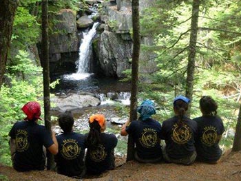 MCC Alumni in woods after work project