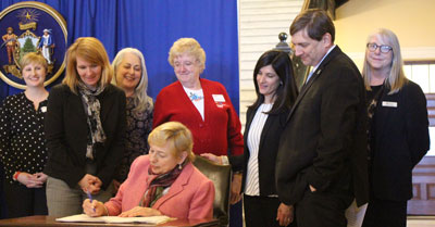 Photo of Governor Mills signing LD1