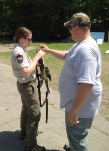 Regional Wildlife Biologists Sarah Spencer and Bob Cordes load a practice dart though the end of the stock of a X-Caliber Pneu-Dart CO2 rifle projector