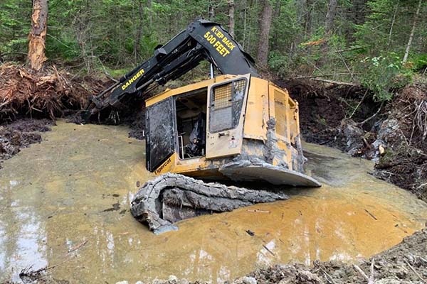 Excavator sinking in mud