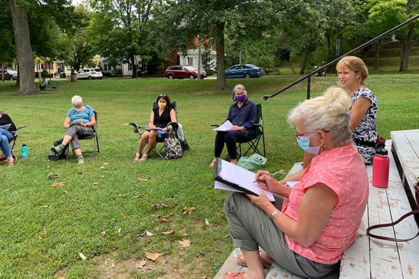 A group of people sitting on a town green