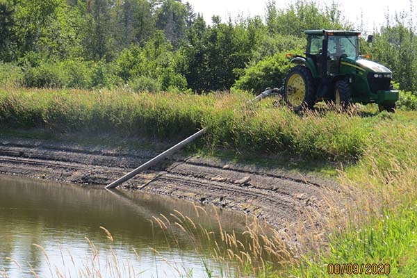 Farmer removing water from low pond