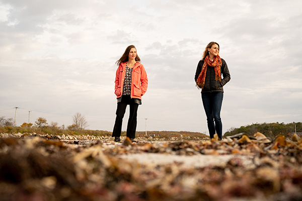 Two women standing on the shoreline