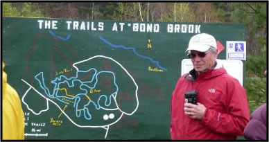 gentleman standing in front of Bond Brook Trails map.