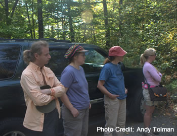 People listening to a presentation outdoors.