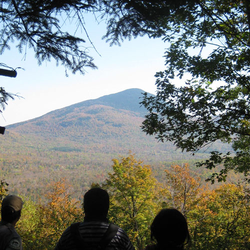 mountain folaige in distance looking over shoulder of couple