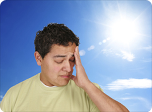 a man holds his head in the glaring sun