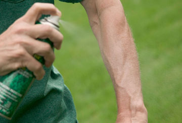 Tick repellent spraying on an arm