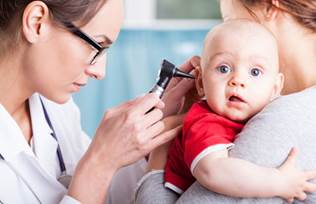 Baby having ears examined by doctor