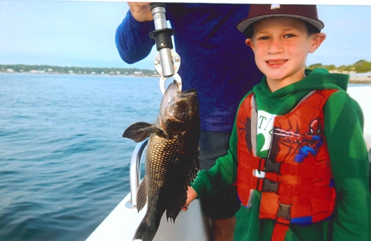 Child with a black sea bass
