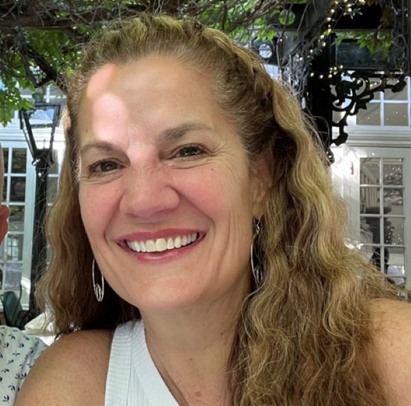 Colette Sullivan wearing white shirt, outside with shops in the background