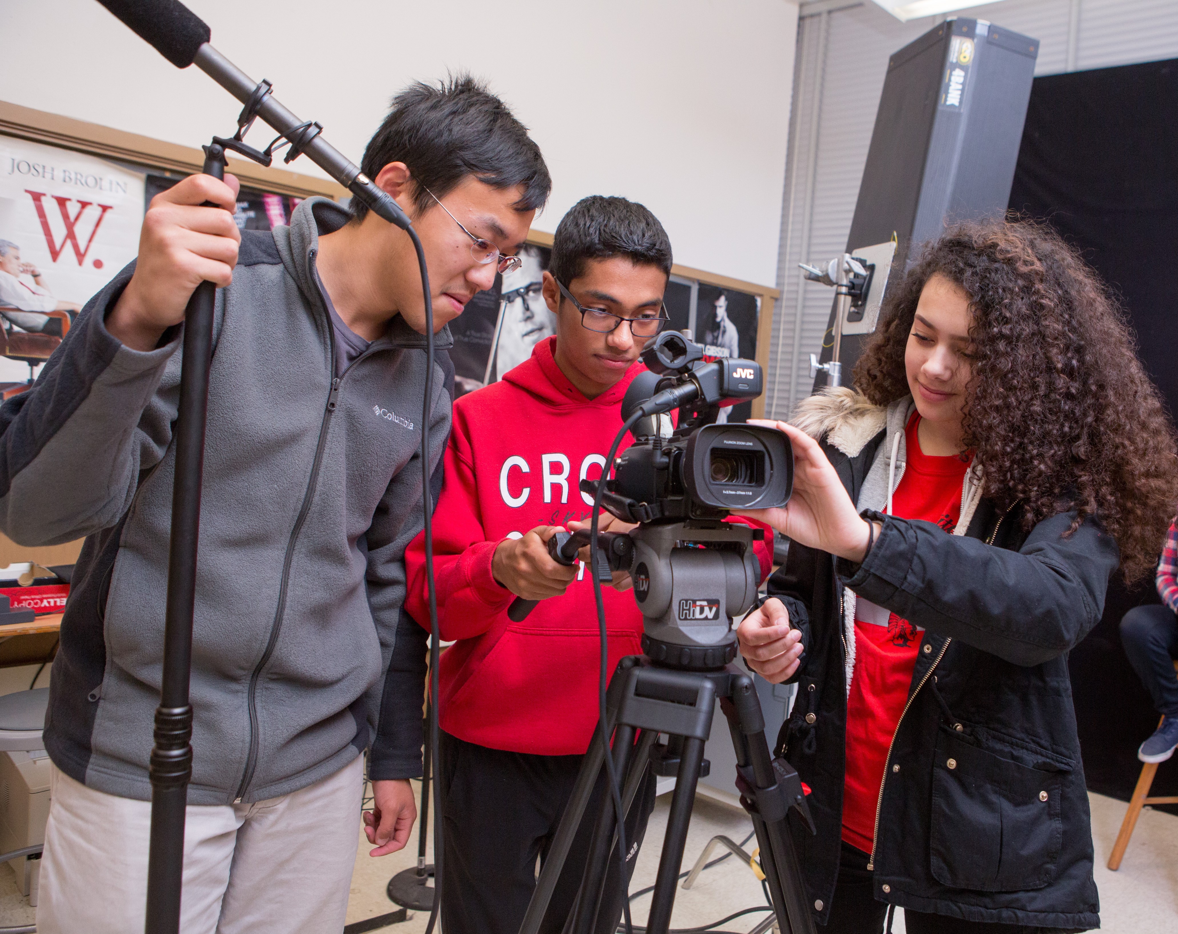 Three students in high school preparing to film a presentation. 