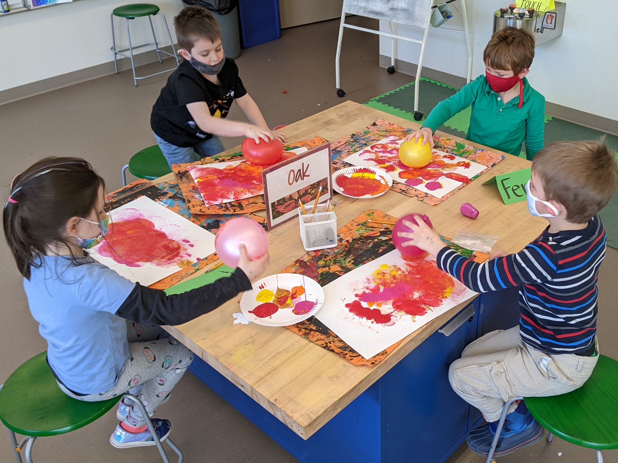Four children painting with balloons