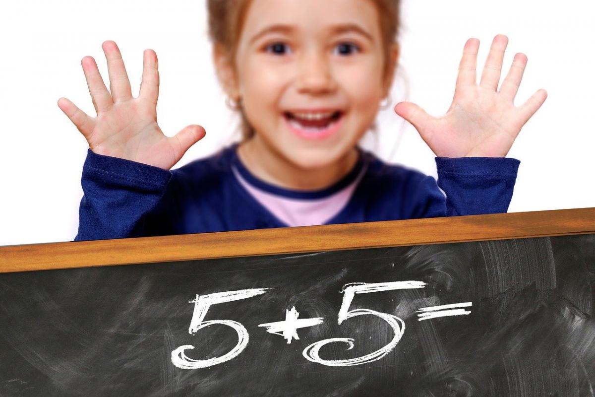 Child showing five fingers on each hand modeling 5 + 5