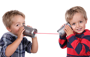 two kids talking with cans and string