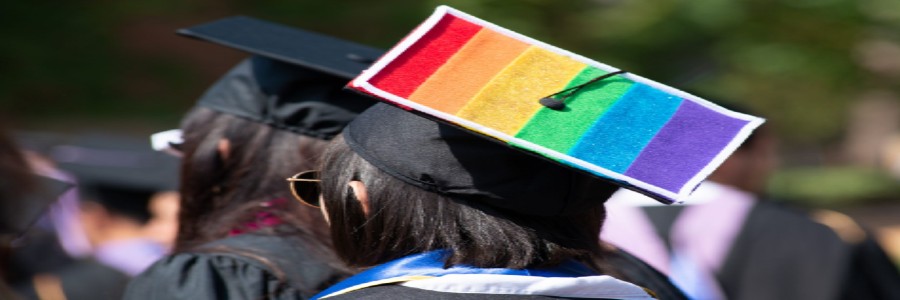 back of a graduate who has a rainbow painted onto mortarboard