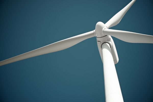 Blades of a wind turbine against a deep blue sky