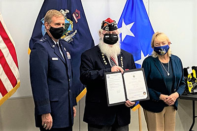 Photo: Major General Douglas Farnham (left), PO3 James Bachelder (center), and Governor Janet Mills (right) at the Aides-de-Camp induction ceremony