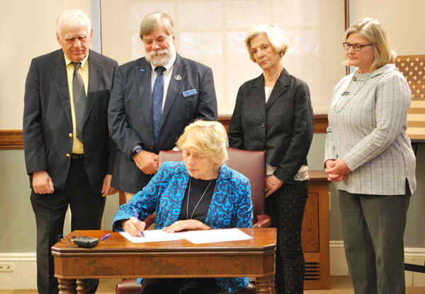Photo of Governor Mills signing the Executive Order