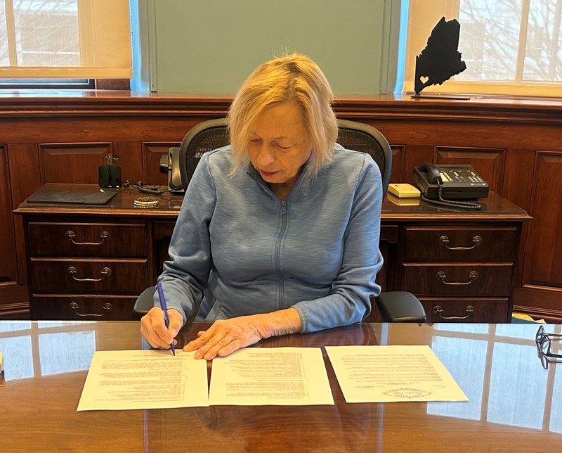 Governor Mills signing the Executive Order