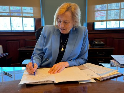 Governor Mills signs the bill in her office