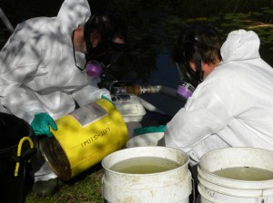 Biologists mix the chemical Rotenone with water taken from the pond prior to application
