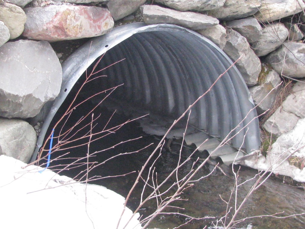 A half culvert like this one, place on cement footings, allows for a natural stream bottom that allows for the passage of fish and other species.