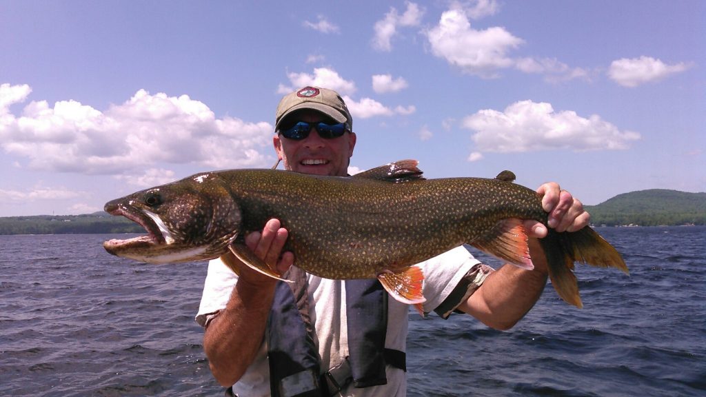 Greg Massey hoists a 12.5 pound Sebago Lake togue. Biologists are using nets and modeling to get a more accurate population estimate of Sebago Lake togue. The data collected will be invaluable for evaluating current and future regulations, as well as managing the lake.