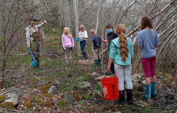 A biologist talks with students outside.