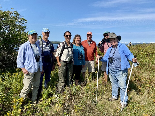 Group of people standing in field on an island.