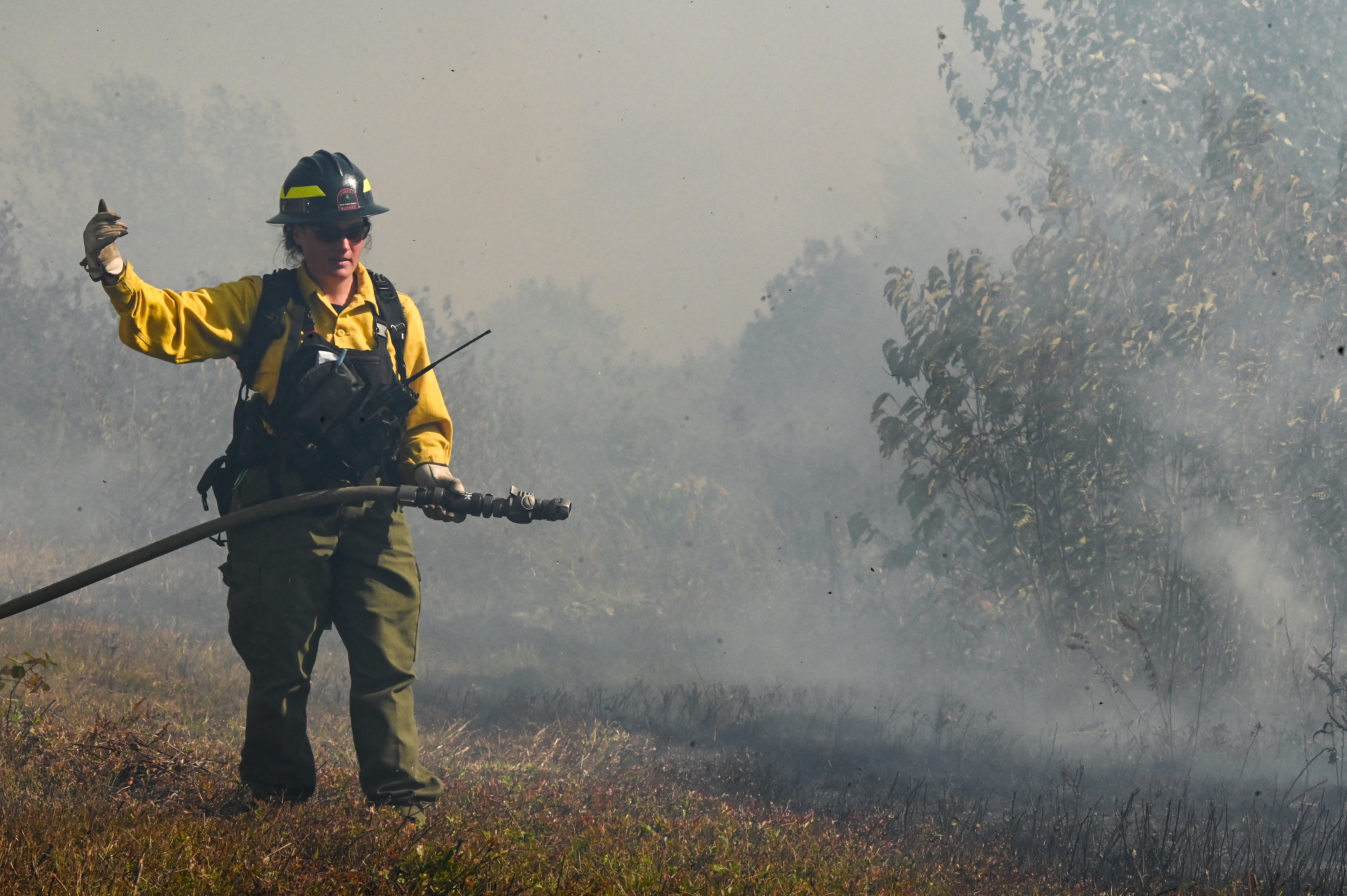 burn crew member using a fire hose
