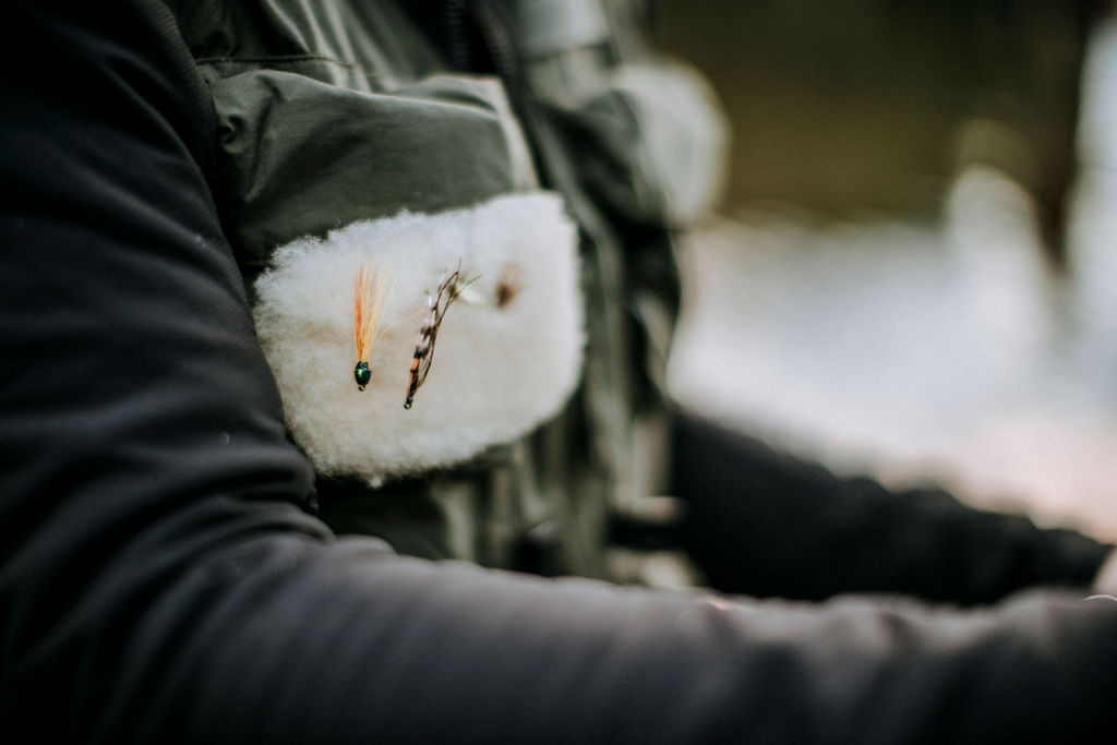 A close up of the vest of a fly angler