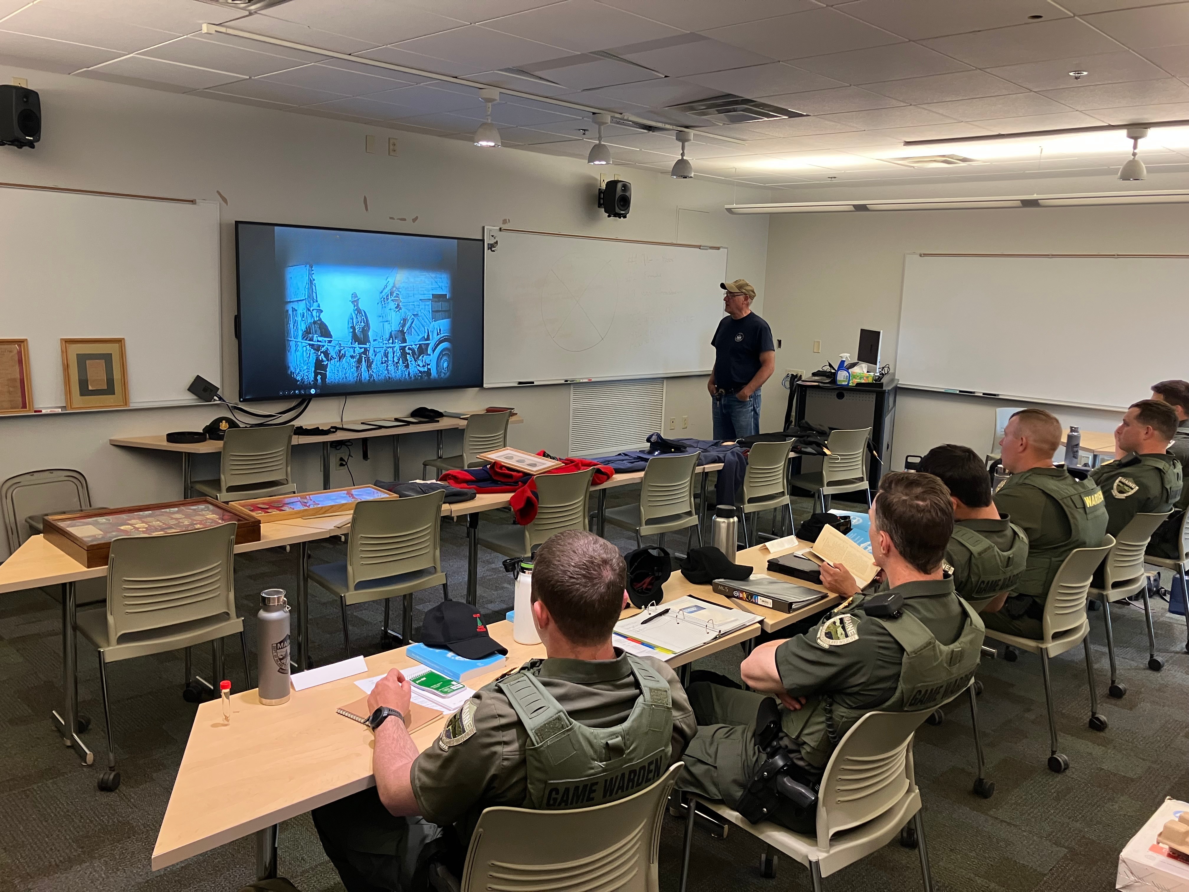 wardens in a classroom watching a powerpoint presentation