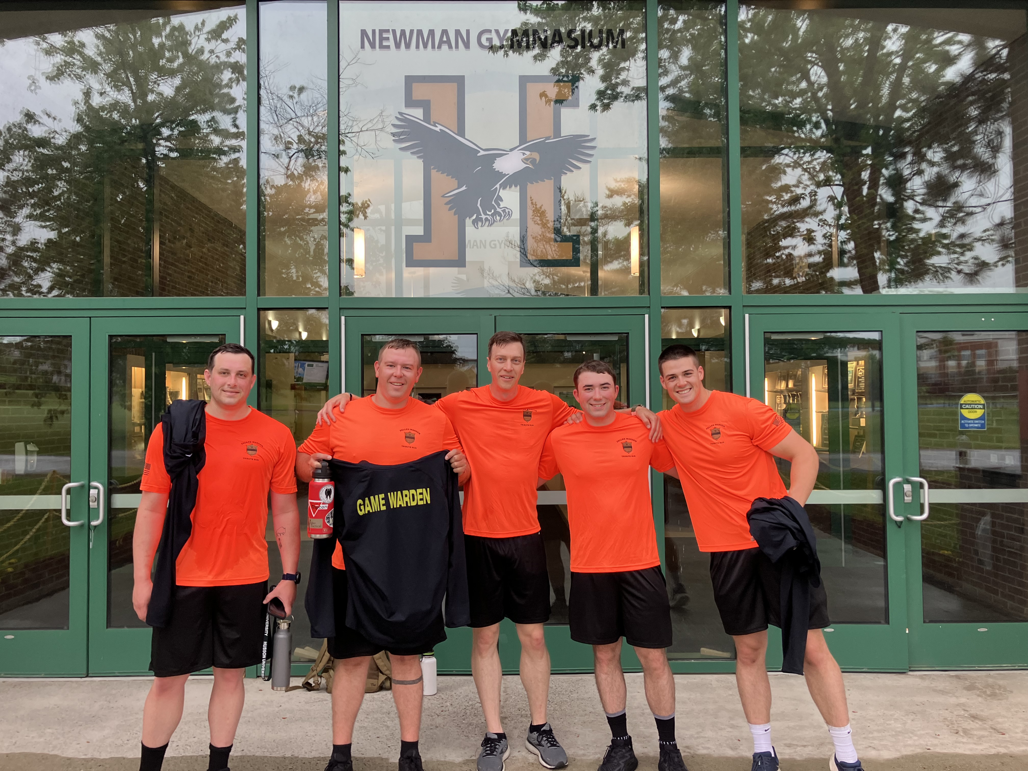 Wardens standing in front of Husson College gym