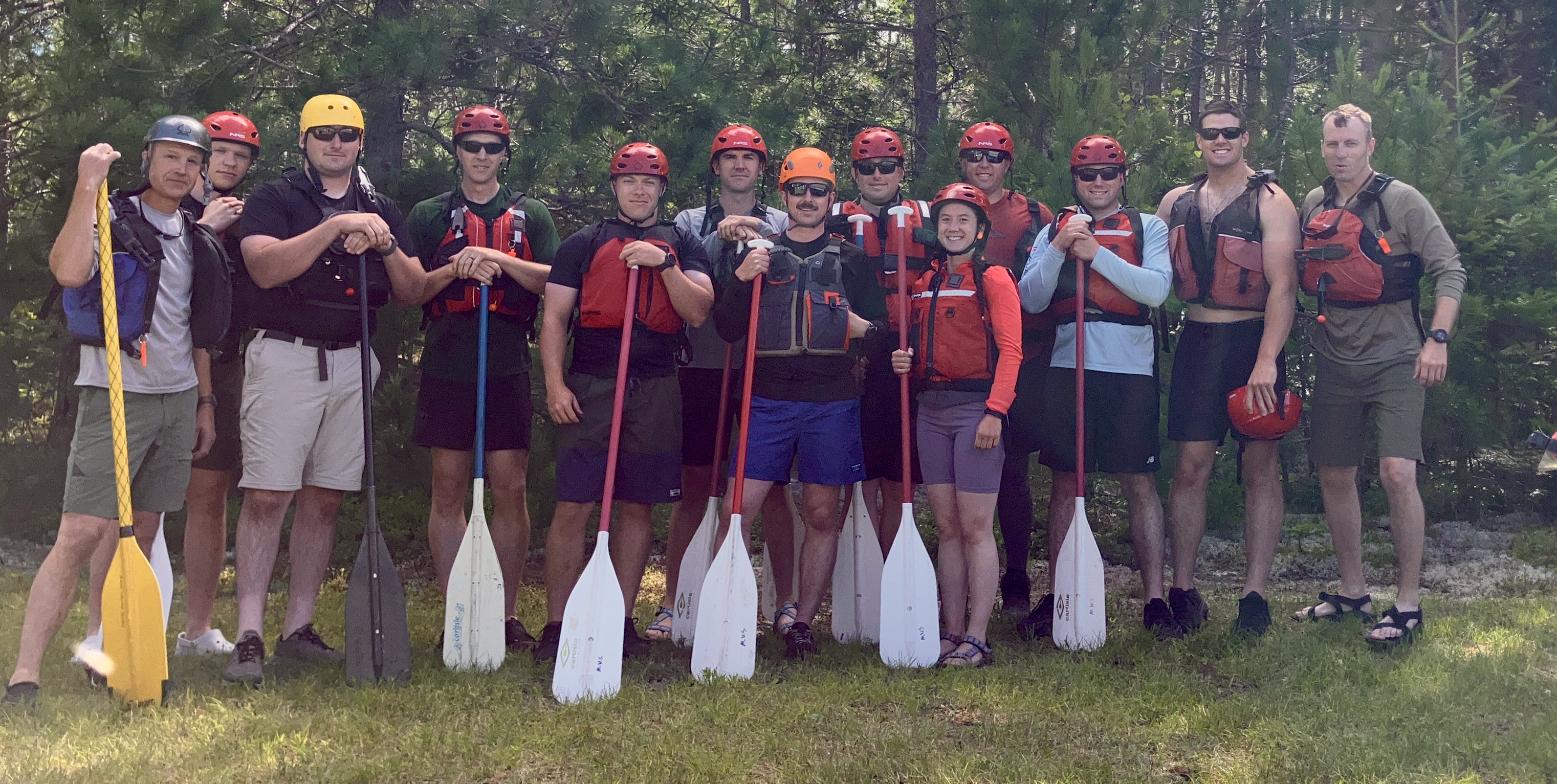 Group of wardens holding paddles after whitewater rafting training
