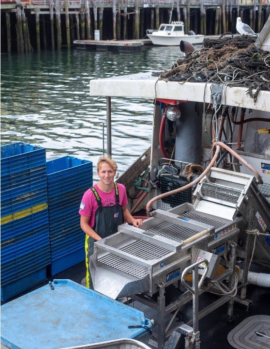 Pre-apprentice Andrew Hoffman stands on a boat used for mussel harvesting at Bangs Island Mussels in Portland.