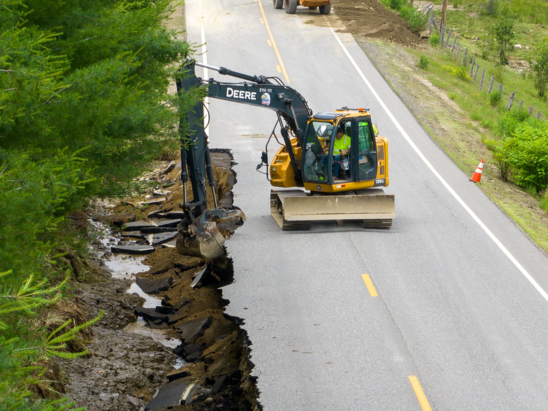 Excavator repairing a damaged road culvert