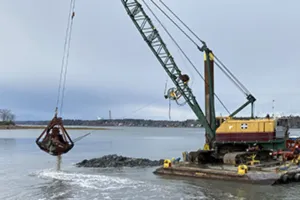 A crane pulling debris up from the ocean floor.