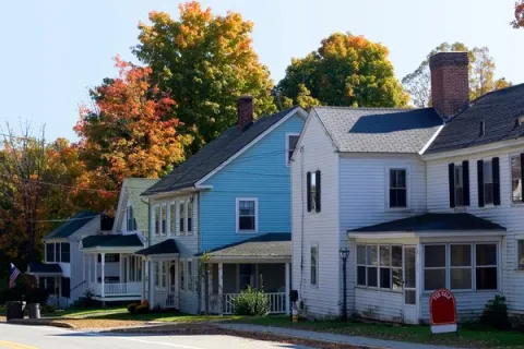 Houses in a row, with a for sale sign in front on one of them