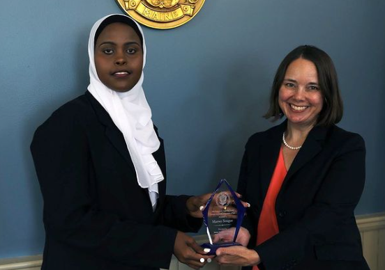 Two women holding a glass award