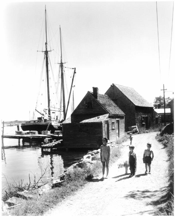 Photo of Four children stroll with their dog by a two masted schooner in Stonington