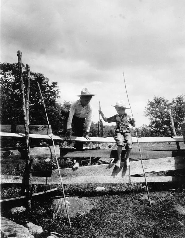Photo of Two boys on a fence with alder fish poles and fish, 1939
