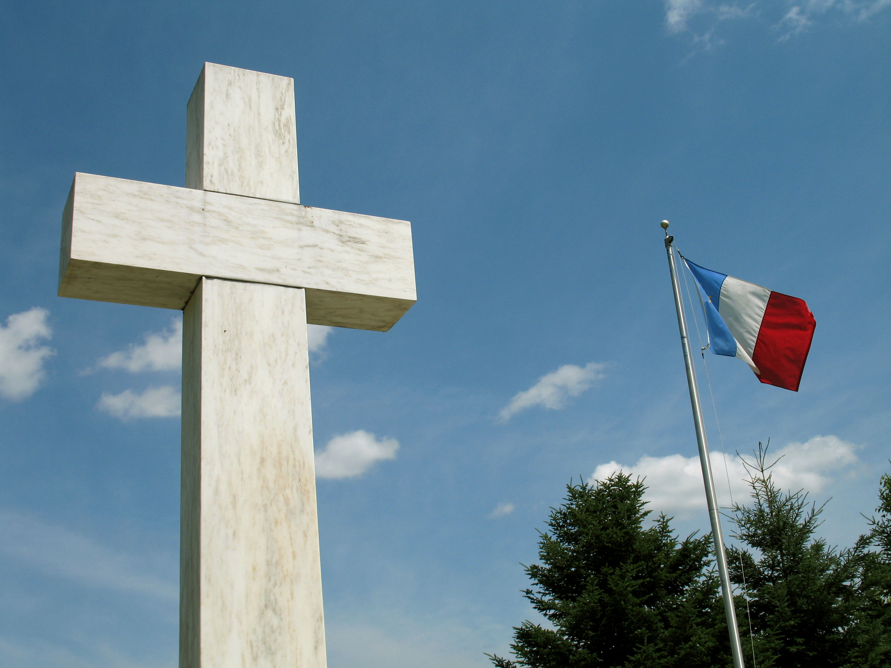 Tall cross next to a french flag