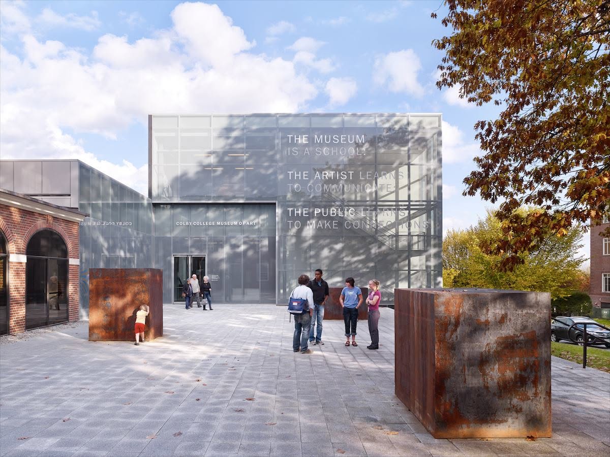 Glass building that's an art museum, students walking in front