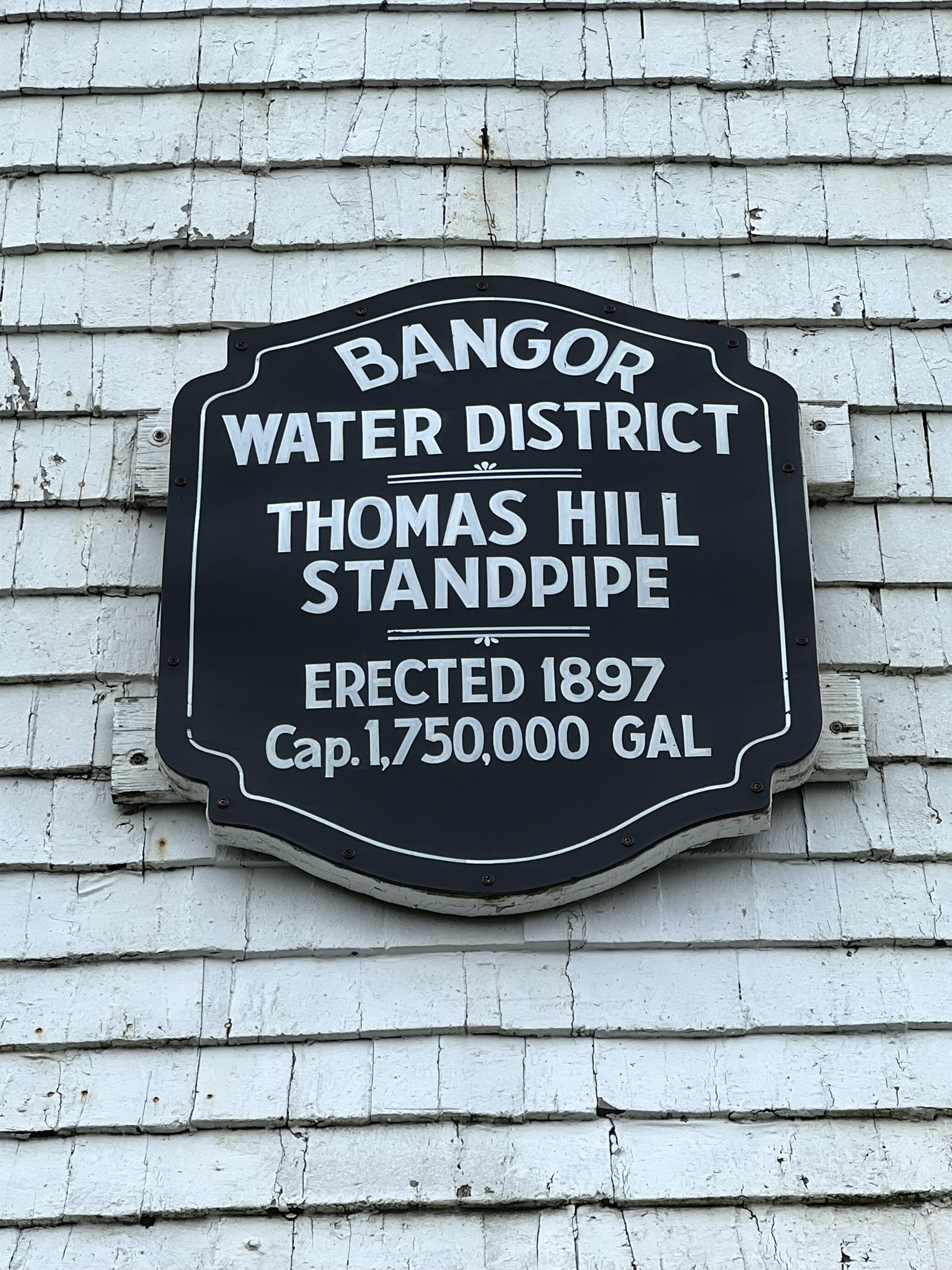 Close-up of a plaque on the Bangor Standpipe reading "Bangor Water District, Thomas Hill Standpipe, Erected 1897, Cap. 1,750,000 Gal."