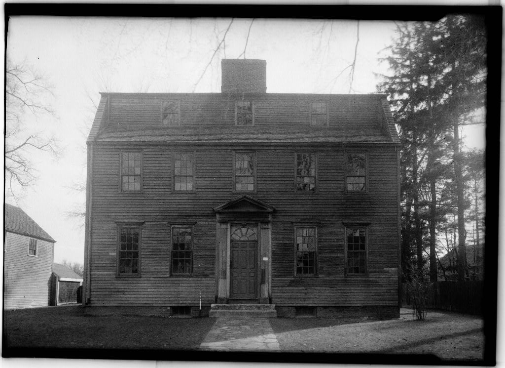 Black-and-white archival photo of the George Tate House exterior, showing the same Georgian facade before restoration, with weathered siding and bare trees flanking the building.
