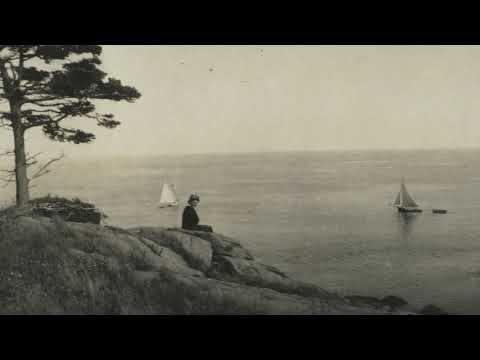 A vintage, grainy black and white photograph showing a person sitting alone on a rocky, tree-lined cliffside. They are looking out over a vast, calm ocean where two sailboats are visible in the distance under a pale sky.