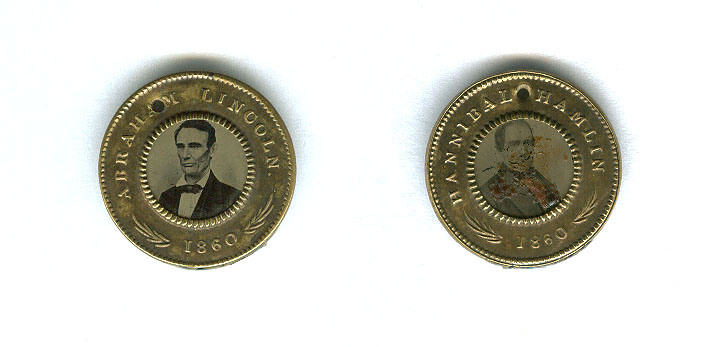 Two matching brass 1860 campaign badges with photographic portraits, one reading "Abraham Lincoln 1860" and the other "Hannibal Hamlin 1860."