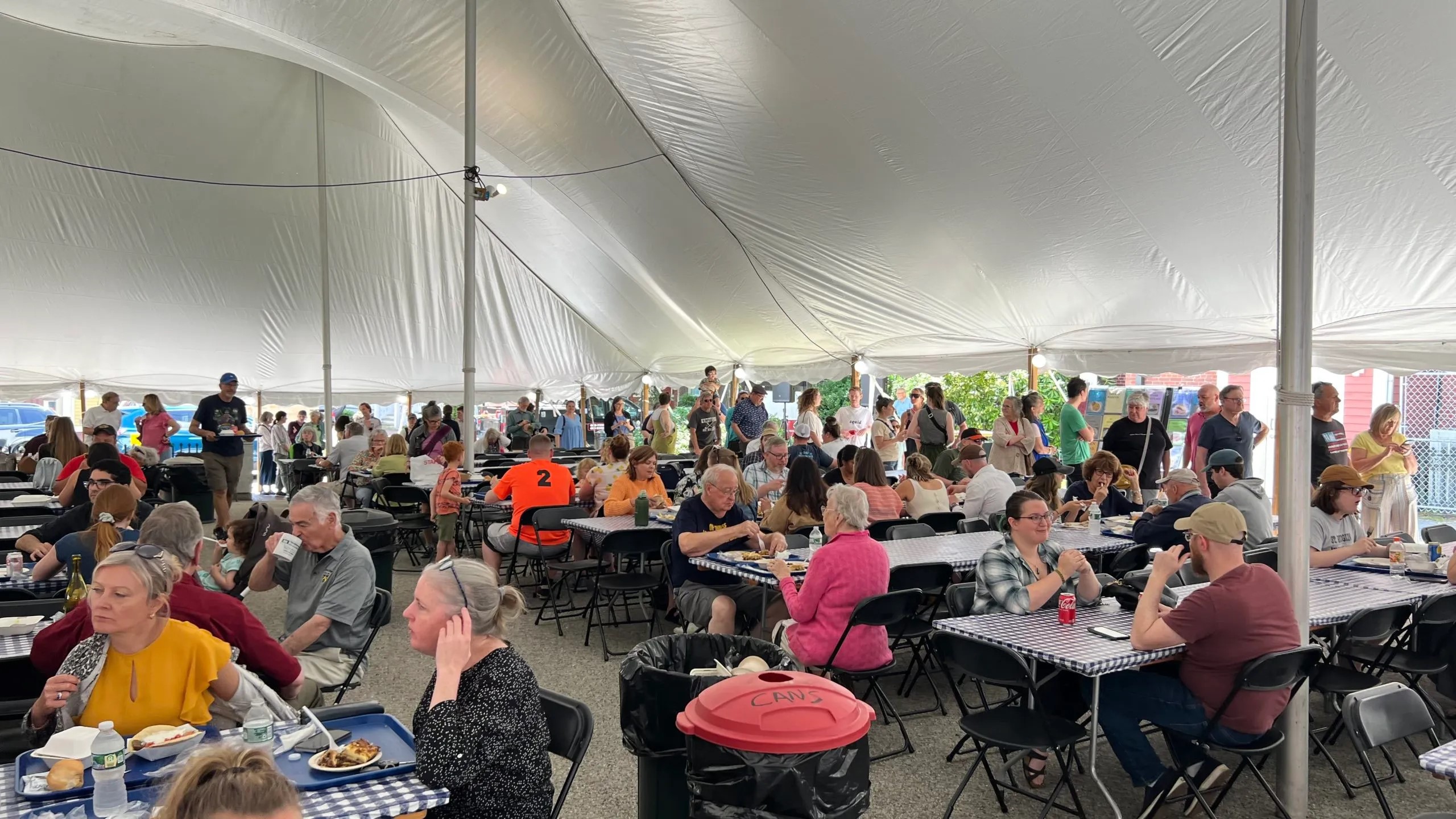 People dining under a large white tent at the Portland Greek Festival hosted by Holy Trinity Church.