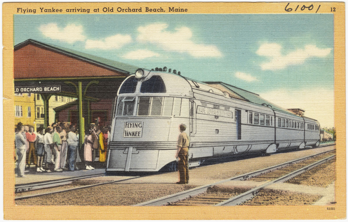 A color-tinted postcard illustration of the streamlined "Flying Yankee" diesel train arriving at the Old Orchard Beach station, with a small crowd waiting on the platform.